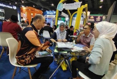 Tawaran istimewa Andalusia Travel turut menarik perhatian Datuk Seri Mohd Nazir Maraslam (kiri) dan Rosli (dua dari kanan) bersama keluarganya.