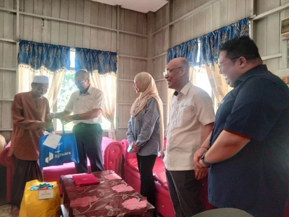 A Halim (kiri) menerima cenderahati daripada Wan Ahmad Dahlan