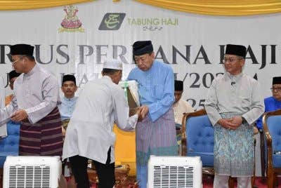 Sultan Sharafuddin menyampaikan sumbangan kepada salah seorang jemaah pada Majlis Kursus Perdana Haji Peringkat Negeri Selangor 1446 Hijrah di Masjid Sultan Salahuddin Abdul Aziz Shah pada Ahad.