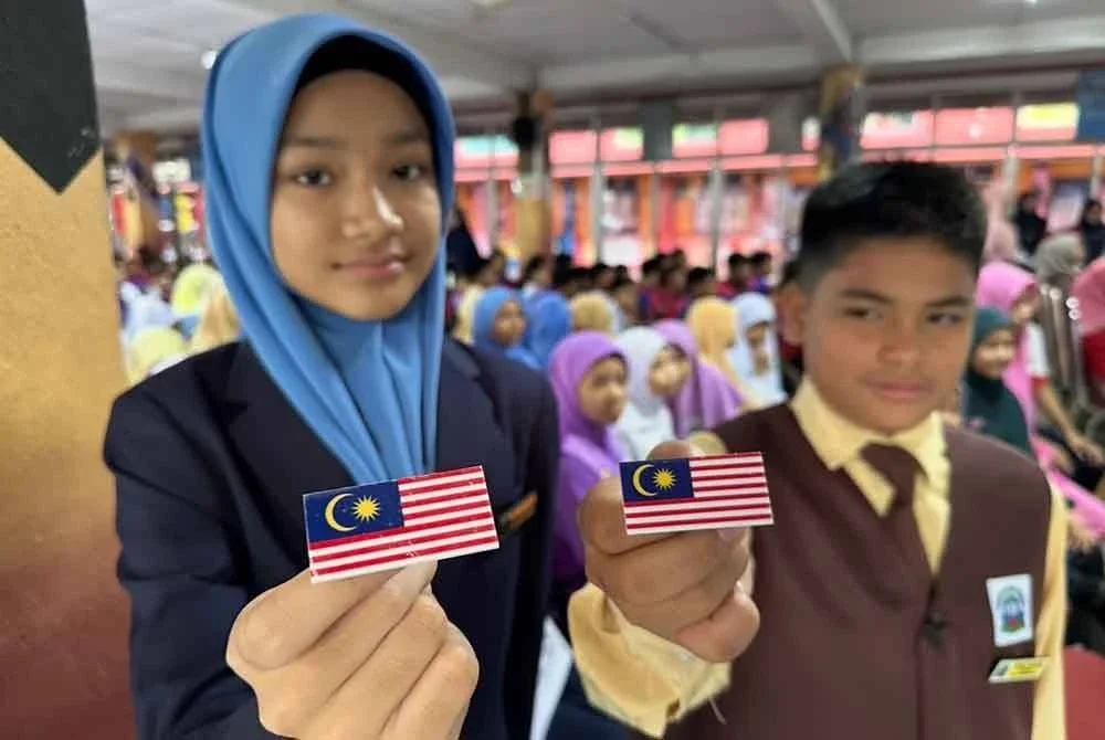 Murid SK Padang Garong menunjukkan lencana Jalur Gemilang.