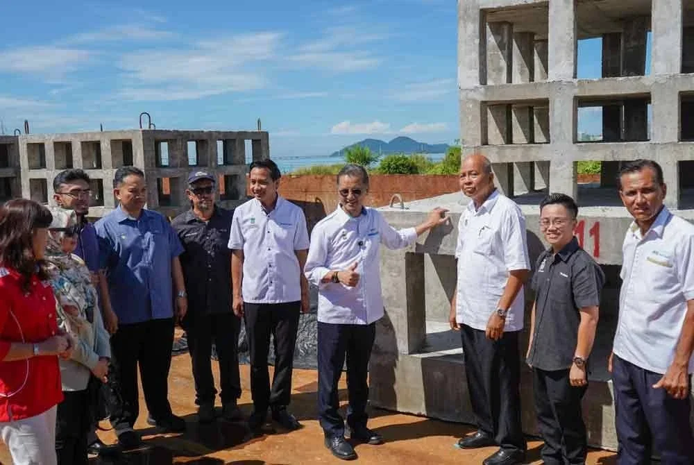 Mohamad (empat dari kanan) dan Farizan (tiga dari kanan) menunjukkan tukun tiruan yang akan ditempatkan di perairan Pulau Kendi.