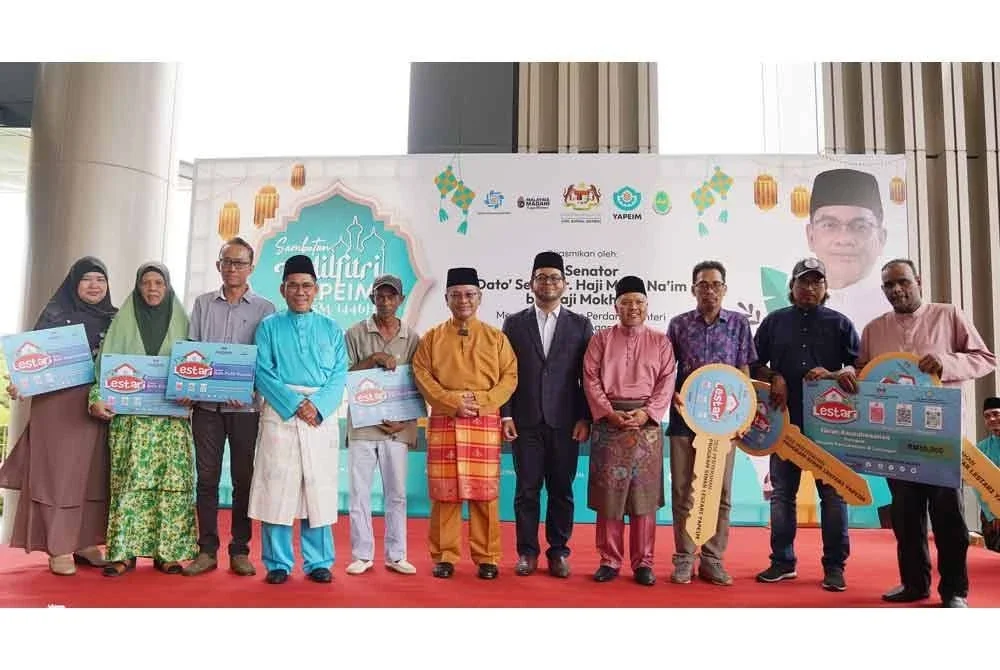 Mohd Na'im (tengah) bergambar dengan penerima Program Sinar Lestari YAPIEM pada majlis Sambutan Aidilfitri YAPIEM yang diadakan pada Isnin.