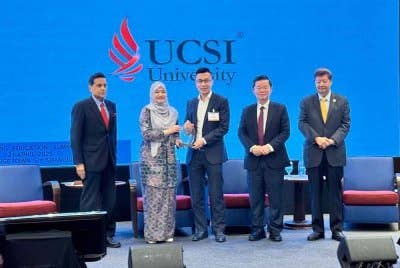 Fadhlina (dua dari kiri) menyampaikan cenderahati kepada peserta Sidang Kemuncak Pemerkasaan Pendidikan 2025.