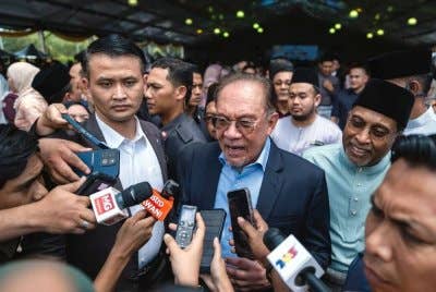 Anwar bercakap kepada pemberita ketika hadir pada Majlis Sambutan Hari Raya Kementerian Pengajian Tinggi pada Isnin. Foto Bernama