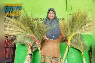 Siti Salmah menunjukkan penyapu hasil air tangannya yang dijual pada harga RM12 sebatang.