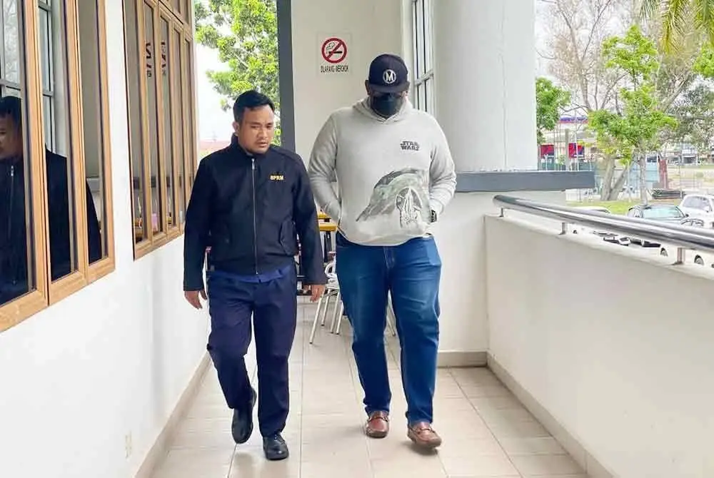 Tertuduh diiringi anggota SPRM semasa hadir di Mahkamah Alor Setar pada Selasa.