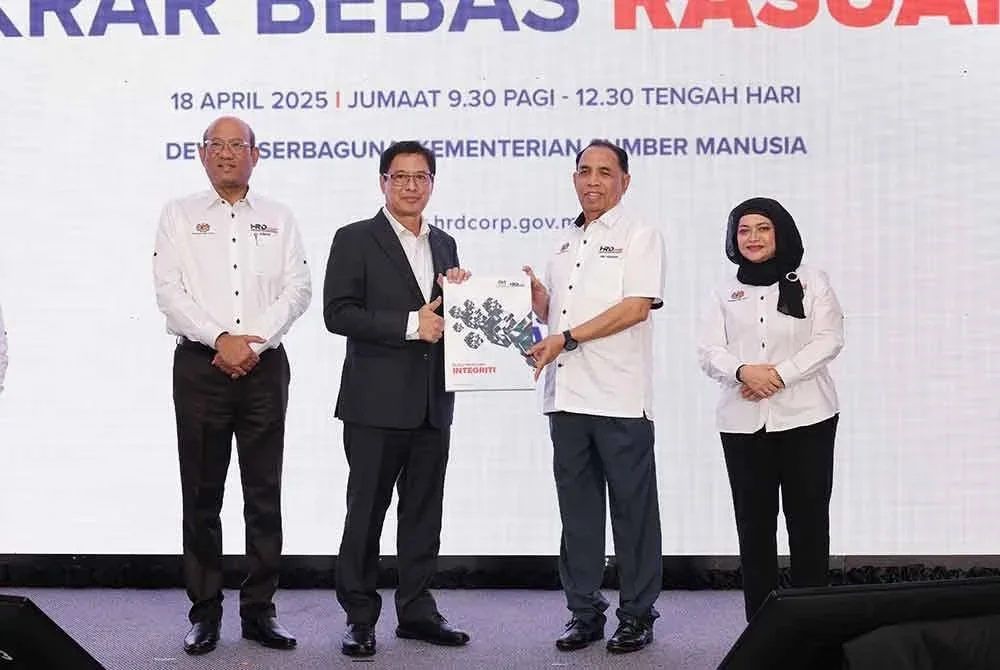 Abu Huraira (dua dari kanan) menyerahkan replika Buku Panduan Integriti HRD Corp kepada Azam (dua dari kiri) untuk diedarkan kepada warga HRD Corp.