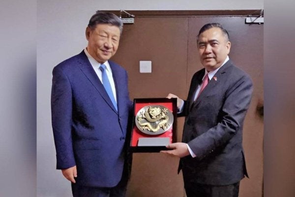 Anthony Loke (kanan) memberikan cenderahati ukiran naga kepada Presiden China, Xi Jinping baru-baru ini. Foto FB Anthony Loke