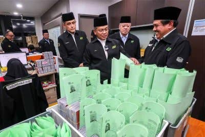 Menteri di Jabatan Perdana Menteri (Hal Ehwal Agama), Datuk Dr Mohd Na’im Mokhtar (tiga dari kanan) melihat Visa Jemaah Haji ketika mengadakan lawatan dan sesi ramah mesra ke Unit Proses Visa Haji bagi meninjau persiapan pengurusan visa jemaah haji musim 1446H/2025M di Menara TH Tun Razak malam ini. Foto Bernama