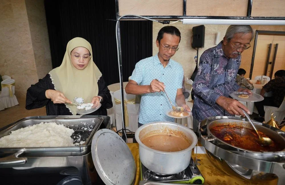 Tetamu yang hadir menikmati hidangan pulut, serawa dan gulai ikan temenung yang disediakan pada majlis Hari Raya 'Riang Ria UJ Raia'.
