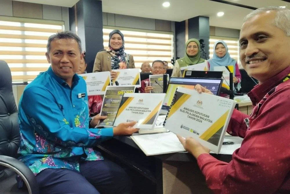 Safuan (kiri) menunjukkan statistik peningkatan pencapaian bagi keputusan peperiksaan SPM 2024 di Bilik Seri Budi, Jabatan Pendidikan Negeri Perak pada Khamis.