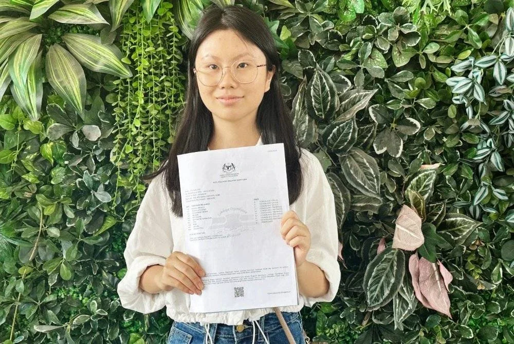 Wan Lin menunjukkan slip keputusan peperiksaan SPM yang diterimanya.