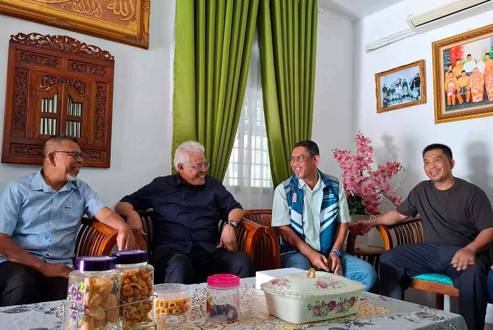 Hamzah (dua dari kiri) bersama Ahmad Faizal (tiga dari kiri) sempena Ziarah Kasih di kediaman Mohamad Amri Zainuddin (kiri) di Kampung Dato Kamaruddin pada Khamis.