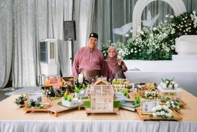 Nurulaini (kanan) dan suaminya bergambar bersama model hantaran perkahwinan mereka.