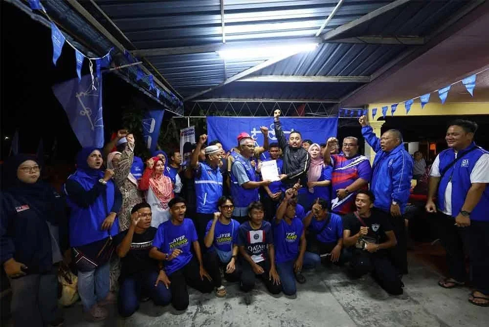 Adham Iskandar menyerahkan borang borang keahlian baru UMNO kepada Pemangku Ketua UMNO Bahagian Tapah di Pusat Daerah Mengundi (PDM) Simpang Tiga dekat Bidor pada Khamis.