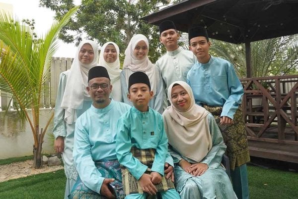 Nor Azwadi (tiga dari kiri) bersama enam anak dan isterinya.