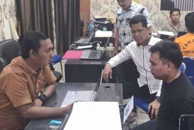 Pegawai penyiasat dari Ibu Pejabat Polis Daerah OKU Timur menyoal siasat Gusmadi. Suspek mengakui telah menembak mangsa selepas berlaku pertengkaran hebat di kediaman mereka. Foto Agensi