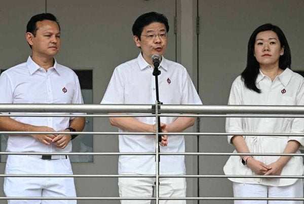 Perdana Menteri Singapura, Lawrence Wong bersama Zaqy (kiri) Mohamad dan Hany Soh (kanan) semasa hadir ke pengumuman pencalonan bagi Pilihan Raya Umum Singapura. - AFP