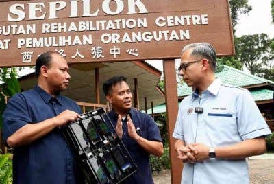 Fahmi (kanan) diberi penerangan mengenai kualiti liputan oleh Penolong Pengarah Suruhanjaya Komunikasi dan Multimedia Sabah, Mohd Yaman Yusof (dua, kanan) sewaktu mengadakan pengujian kualiti liputan komunikasi kawasan pelancongan di Sepilok. Foto Bernama
