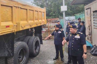 Muhammad Kifli (kanan) menunjukkan sebuah lori muatan pasir yang disita selepas ditahan JPJ di Putrajaya pada 12 April lalu.