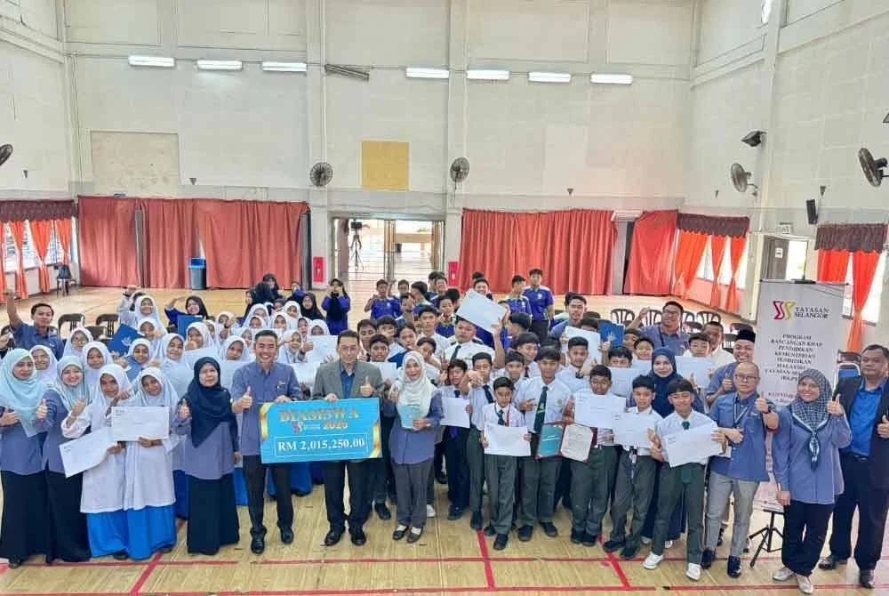 Raja Nazirin (tujuh dari kiri) bersama sebahagian pelajar yang menerima tawaran biasiswa Yayasan Selangor di Dewan Bestari Asrama Yayasan Selangor Klang pada Selasa.