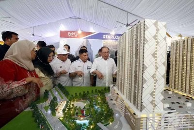 Anwar (kanan) melihat model rumah mampu milik pada Majlis Pecah Tanah Projek Pembangunan Rumah Belia MADANI dan Rumah Mampu Milik di Mukim Batu, pada Selasa. Foto Bernama