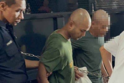 Tertuduh (tengah) dikawal ketat polis ketika dibawa ke Mahkamah Butterworth pada Rabu.