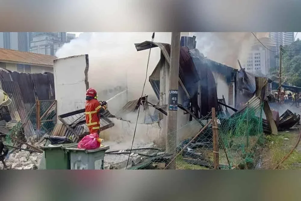 Anggota bomba memadamkan kebakaran melibatkan tiga rumah di Pintasan Raja Muda Musa 4, Kampung Bahru pada Khamis.