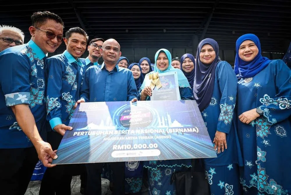 Nur-ul Afida meraikan kejayaan Bernama meraih Anugerah Media Terbaik (Agensi) bersama pengurusan tertinggi dan para petugas Bernama sempena sambutan Hari Pekerja Peringkat Kebangsaan 2025 di Axiata Arena, Bukit Jalil pada Khamis. Foto Bernama