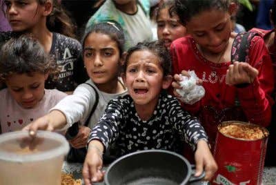 Penduduk Palestin berkumpul untuk menerima makanan di pusat agihan makanan di Kem Pelarian Nuseirat, di tengah Semenanjung Gaza. Foto AFP