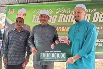 Dr Izani (tengah) menerima sumbangan daripada wakil syarikat kerajaan negeri Kelantan.