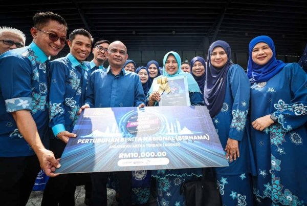 Nur-ul Afida meraikan kejayaan Bernama meraih Anugerah Media Terbaik (Agensi) bersama pengurusan tertinggi dan para petugas Bernama sempena sambutan Hari Pekerja Peringkat Kebangsaan 2025 di Axiata Arena, Bukit Jalil pada Khamis. Foto Bernama