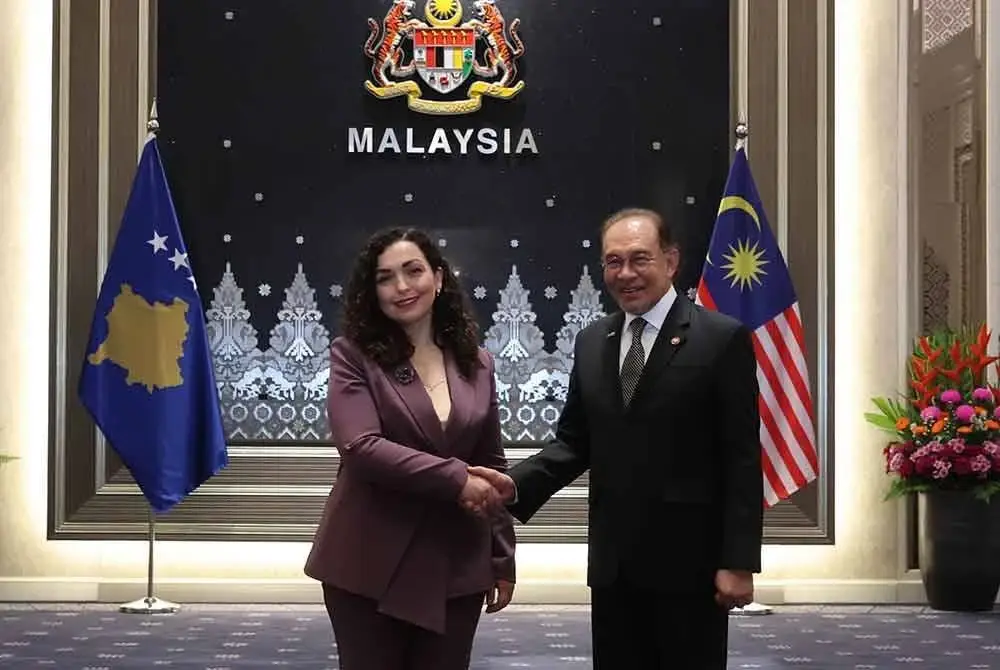 Anwar (kanan) bersalaman dengan Presiden Kosovo Dr Vjosa Osmani Sadriu pada Majlis Jamuan Makan Tengah Hari yang dihoskan oleh Perdana Menteri di Kompleks Seri Perdana pada Jumaat. Foto Bernama