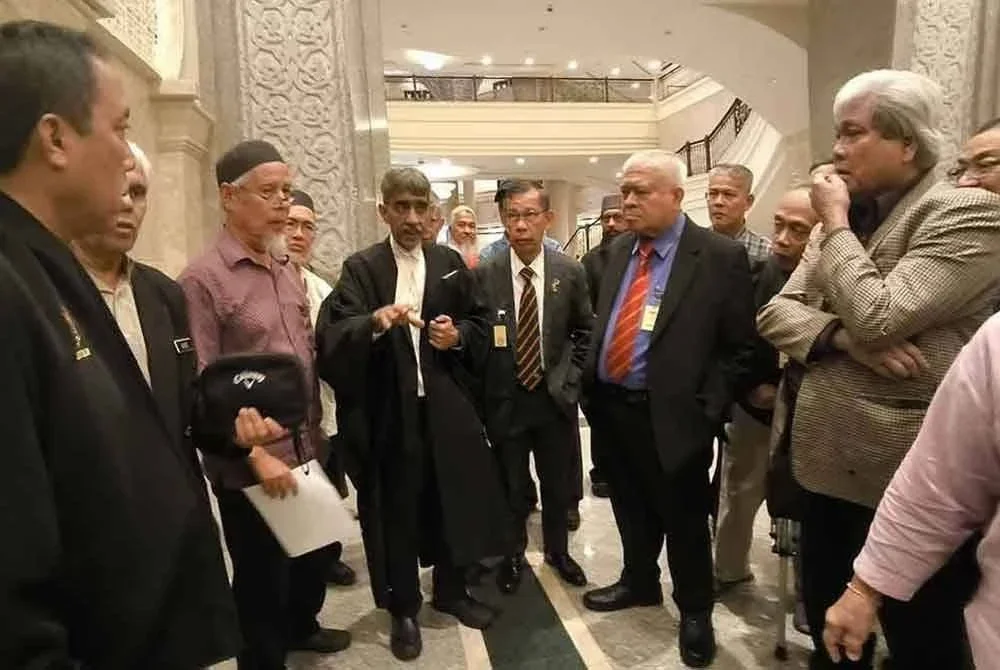 Sebahagian daripada ahli veteran ATM mendengar ulasan Mohamed Haniff (lima dari kiri) selepas hujahan berhubung penyelarasan pencen pesara di Mahkamah Rayuan Putrajaya, 21 Januari lalu.