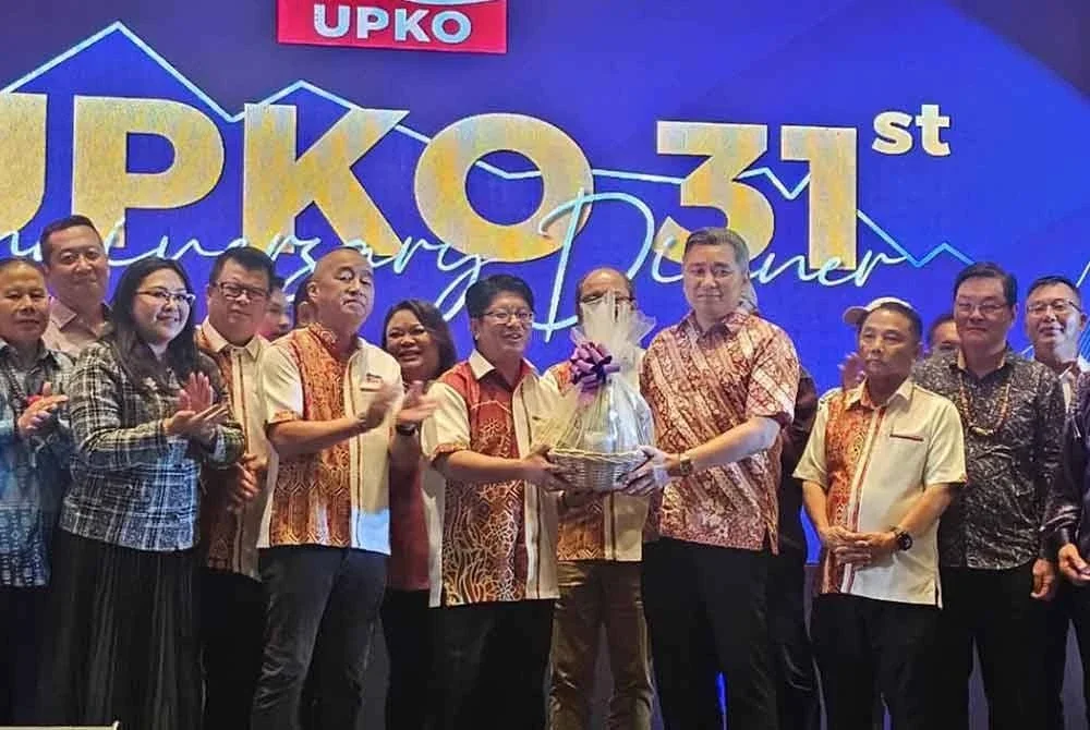 Setiausaha UPKO, Datuk Nelson Angang (kiri) menyampaikan cenderahati kepada Ewon (kanan) pada Majlis Makan Malam Ulang Tahun Ke-31 UPKO di SICC Kota Kinabalu.