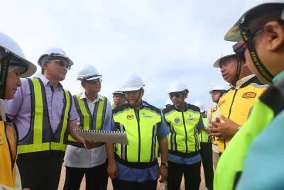 Alexander Nanta Linggi (tengah) diberikan taklimat kemajuan projek pembinaan jalan raya dari ICQS Bukit Kayu Hitam ke CIQ Sadao, Thailand pada Sabtu.