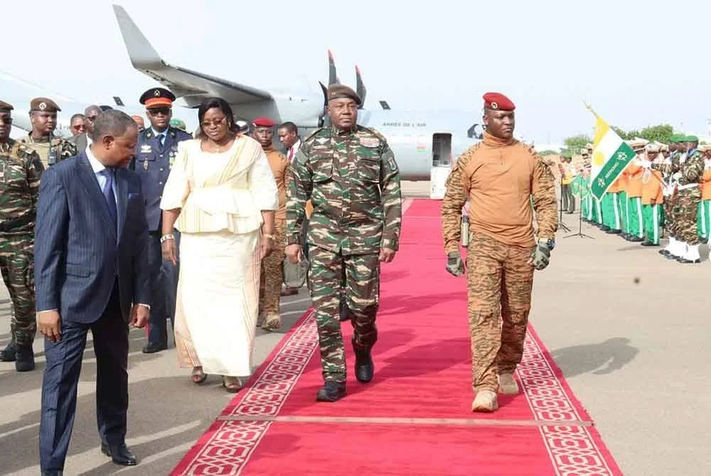 Traore (kanan) disambut Jeneral Abdourahamane Tiani ketika sidang kemuncak pertama blok Perikatan Negara-Negara Sahel (AES) di Niger.