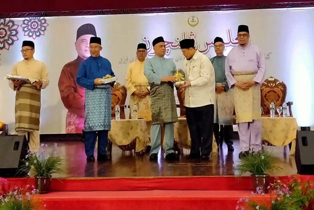 Saarani (depan, tengah) menyampaikan set kepada penerima selepas menyempurnakan Majlis Pelancaran Kitab Bacaan di Masjid, Surau Diri Jumaat dan Surau Ta’addud Jumaat Negeri Perak di ILKKM Sultan Azlan Shah di Tanjung Rambutan, di Ipoh pada Isnin.