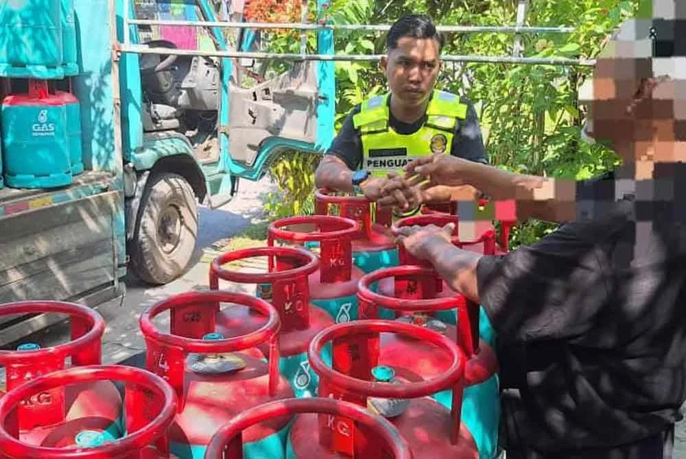 Pegawai dan anggota penguat kuasa KPDN Perak memeriksa beberapa tong LPG dalam serbuan di premis kediaman di Taiping dalam Ops Gasak 2025 oleh KPDN Perak pada Rabu.