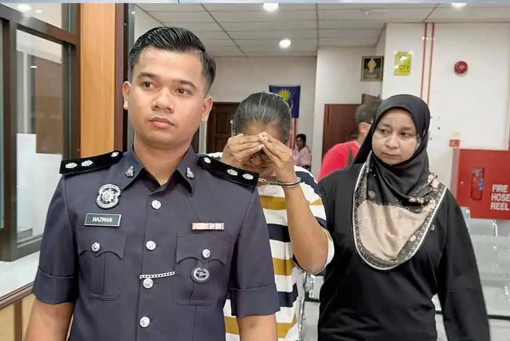 Tertuduh diiringi anggota polis ketika dibawa ke Mahkamah Majistret Butterworth pada Jumaat.