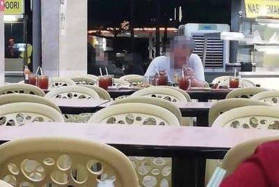 Lelaki warga emas dilihat makan dan berbual dengan lapan kerusi kosong lengkap dengan hidangan di sebuah restoran.