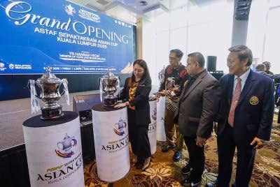 Hannah (kiri) melihat piala kejohanan selepas merasmikan Kejohanan Piala Asia Sepaktakraw 2025 pada Jumaat.