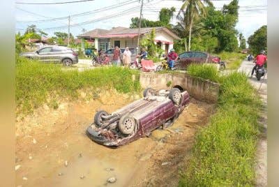Kereta yang dipandu Siti Fatimah terbalik selepas terbabas ke dalam tali air di Kampung Derdap, Limbat pada Sabtu. Foto Bomba