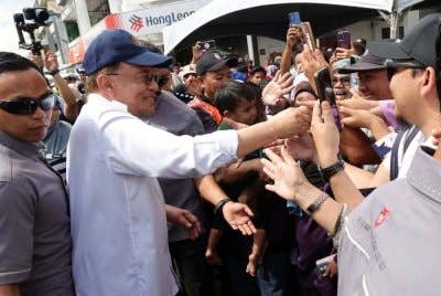 Anwar bersalaman dengan orang ramai ketika tiba bagi merasmikan Majlis Penutupan Program Madani Rakyat (PMR) 2025 Peringkat Negeri Sabah di Dataran Majlis Perbandaran Tawau pada Ahad. Foto Bernama