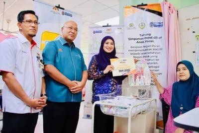 Nasreen Khanum (berdiri, kanan) menyampaikan cek cura Tabung Awal Simpanan Pendidikan Anak Perak kepada penerima
Program Dakapan Kasih di Hospital Seri Manjung.
