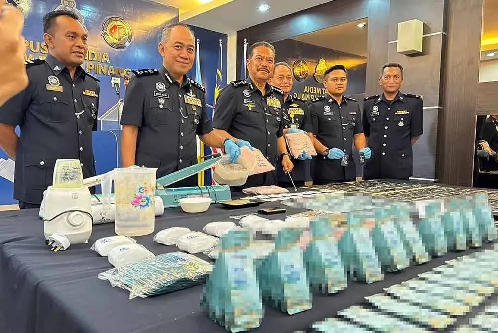 Hamzah (tiga dari kiri) menunjukkan dadah yang dirampas daripada suspek.
