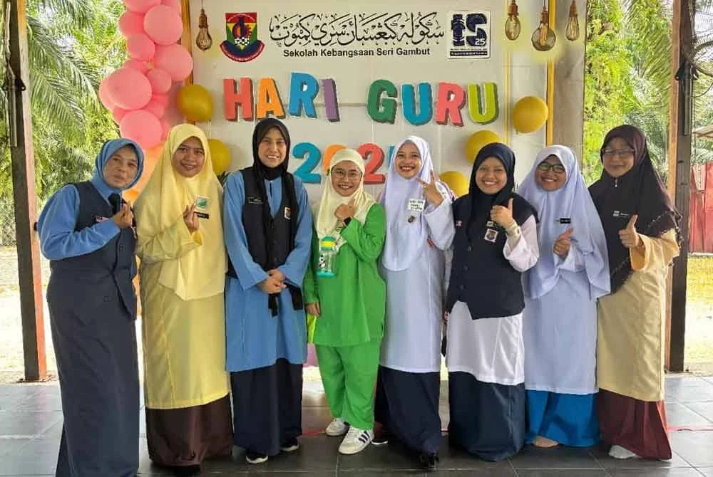Sebahagian guru wanita bergambar semasa mengenakan pakaian seragam sempena Hari Guru di SK Seri Gambut, Tanjong Karang pada Jumaat.