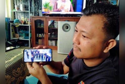 Nizam menunjukkan gambar rakan-rakan yang meninggal dunia ketika mereka sedang bertugas sempena perayaan Chitrapournami di Teluk Intan.