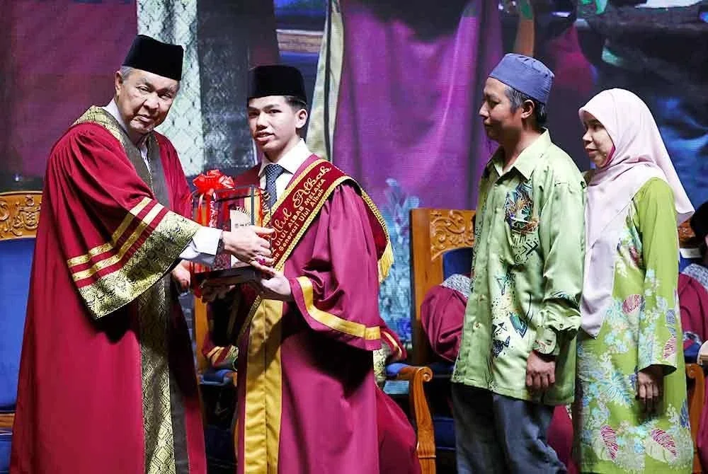 Ahmad Zahid (kiri) menyampaikan Anugerah Tokoh Ulul Albab 2024 kepada Muhammad Ridhwan Faizulazmey (dua dari kiri) pada majlis Graduasi Huffaz dan Apresiasi Kecemerlangan Ulul Albab 2024/2025 di sebuah hotel dekat Ayer Keroh pada Sabtu. Foto Bernama
