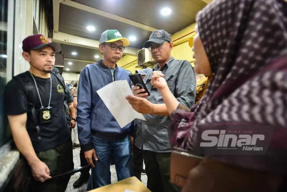 Jefri (dua,kiri) memeriksa dokumen salah seorang warga asing yang ditahan. - FOTO SINARHARIAN/ASRIL ASWANDI SHUKOR
